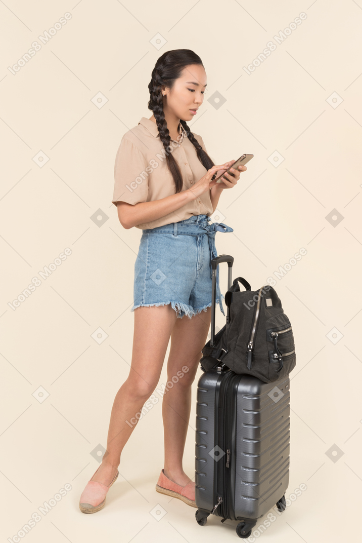 Молодая женщина-путешественница с помощью своего смартфона