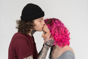 Close-up a young male kissing his girlfriend's forehead