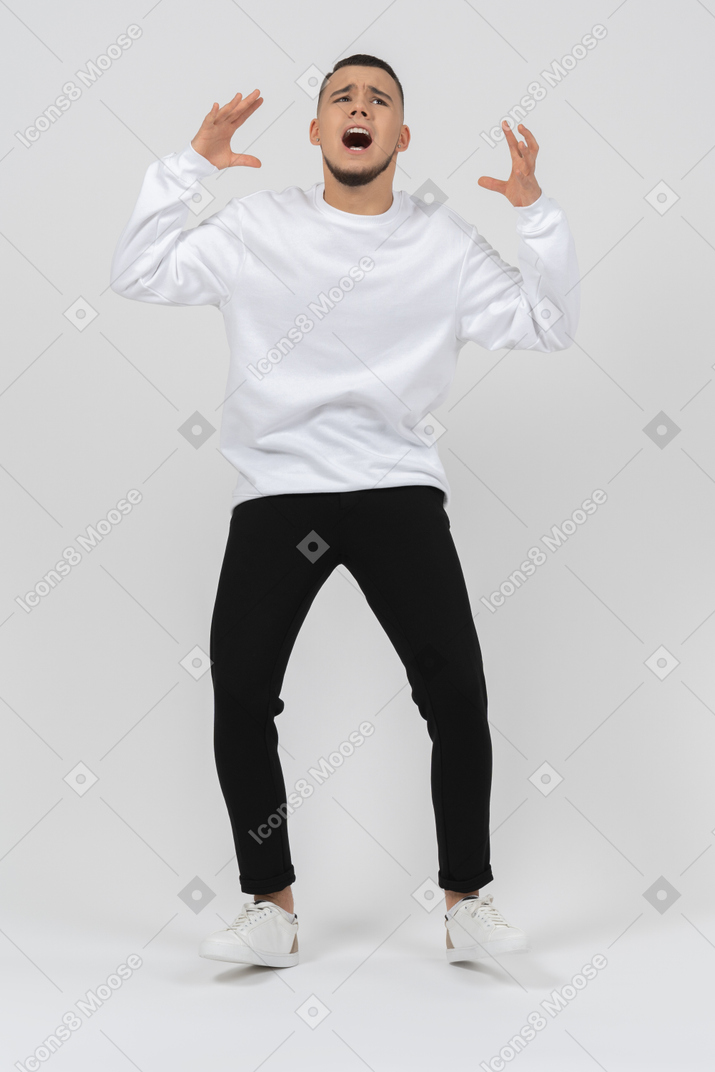 Young man in casual clothes panicking and screaming out