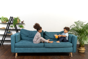 Good looking boy and girl play on the sofa