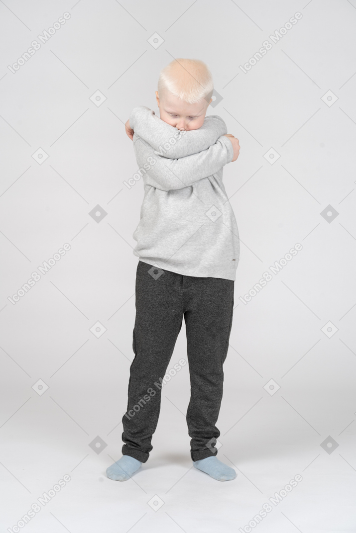 自分を抱き締める小さな男の子