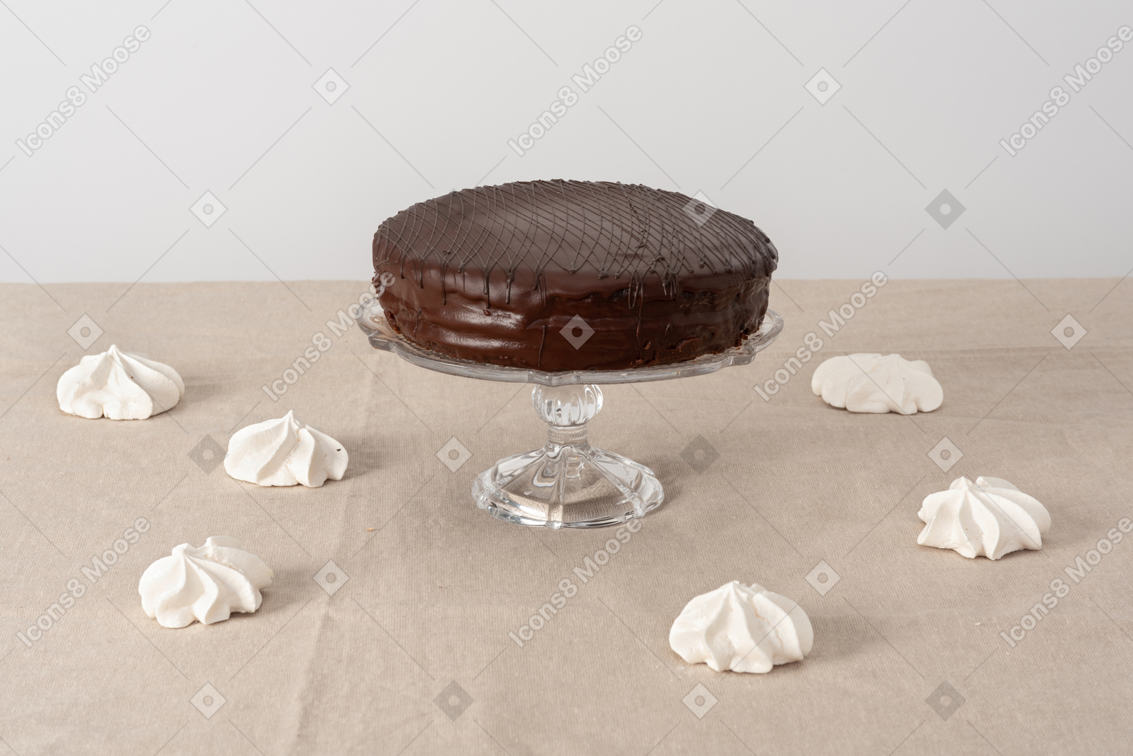 Chocolate cake on glass cake stand and zephyr