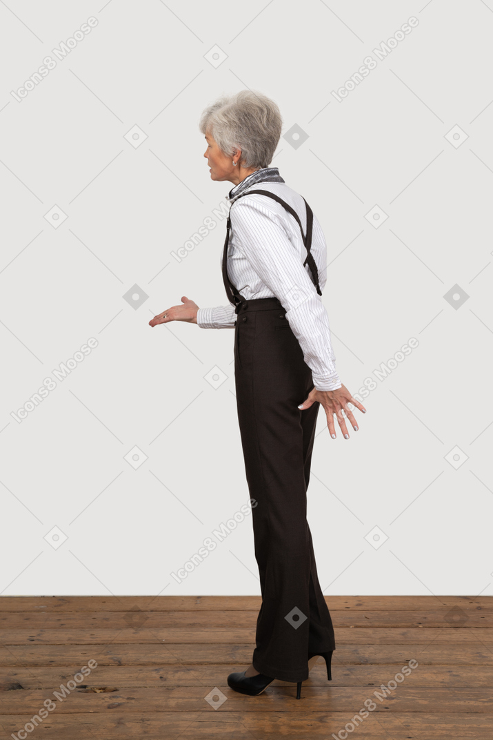Seitenansicht einer alten dame in bürokleidung, die ihre hand ausstreckt