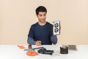 A young man in casual blue clothes working with computer details