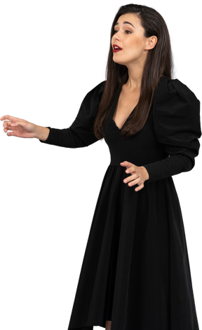 Vista di tre quarti di una giovane donna che canta in un abito nero