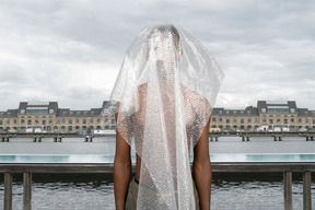 Man in plastic standing near water