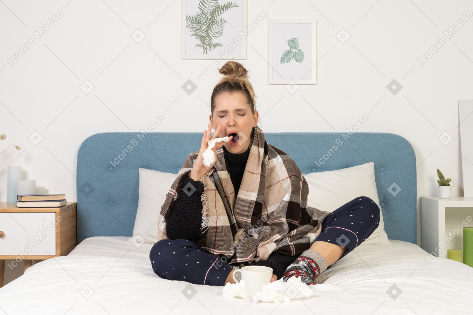Front view of a yawning ill young lady in pajamas wrapped in checked blanket in bed