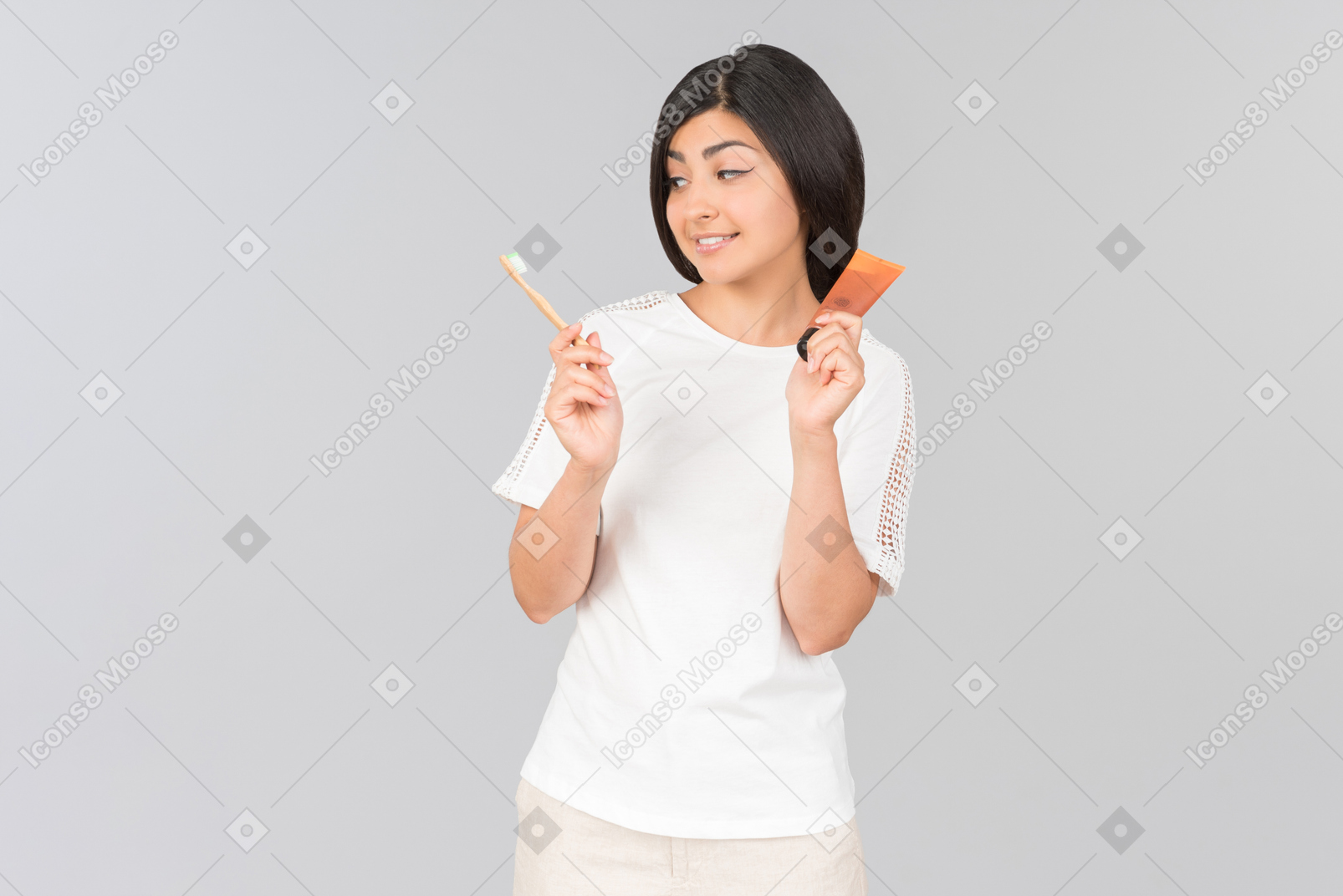 Woman holding toothbrush and cream tube