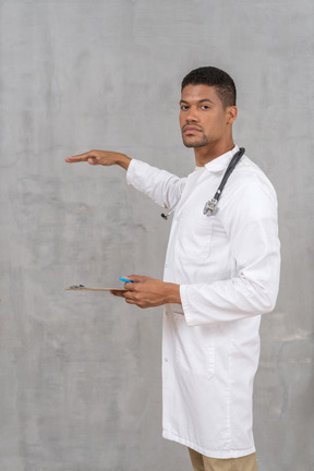 Doctor with stethoscope and clipboard showing height of something