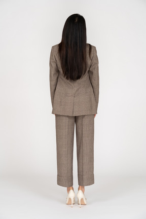茶色のビジネススーツの若い女性の背面図