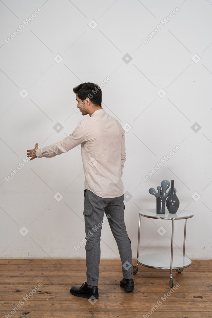 一个穿着休闲服的男人的侧视图，伸出一只手握手