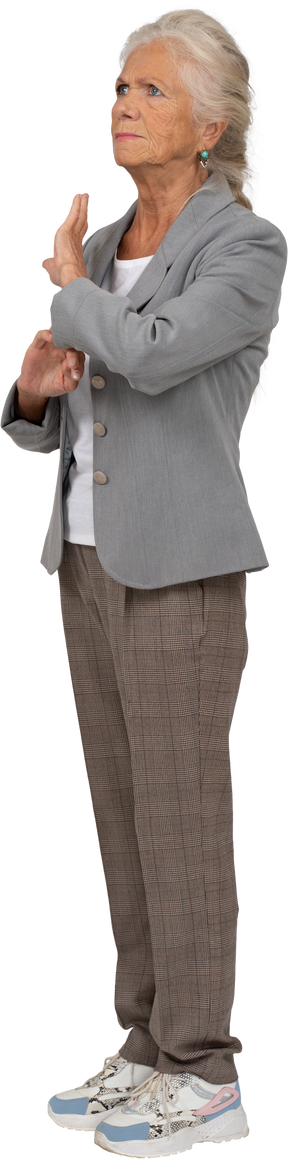 Side viw of an old lady in suit showing stop sign