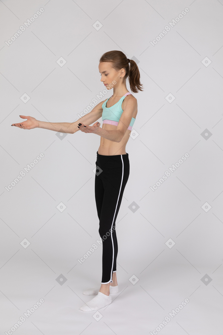Teen girl in sportswear raising her hands