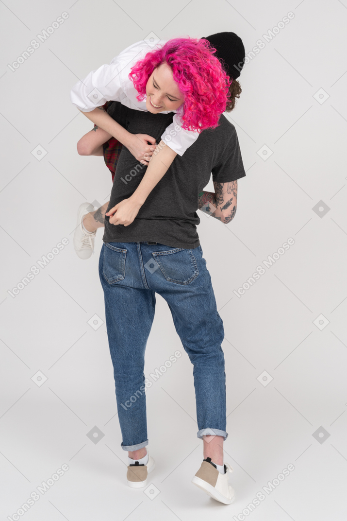 一个年轻人在肩膀上背着他的女朋友的背影