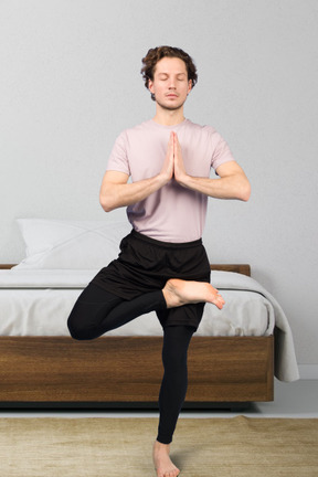 Ajuste joven haciendo yoga en casa