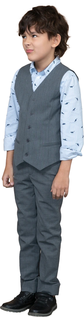 Front view of a cute boy in grey suit making faces