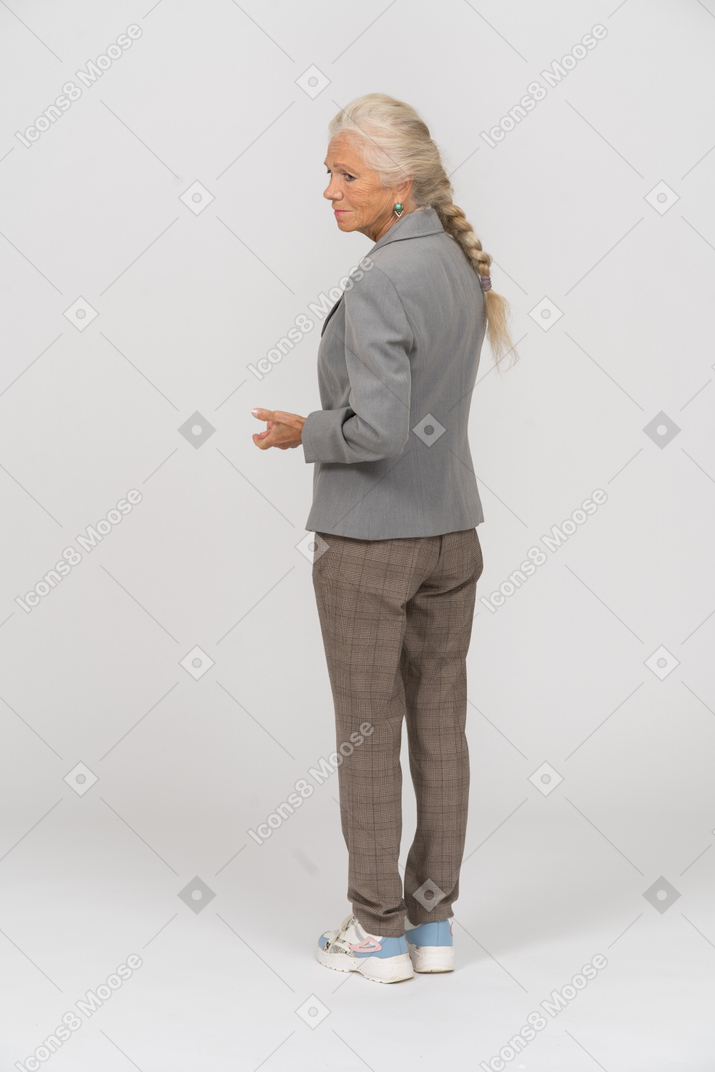 Vista posteriore di una vecchia signora in giacca e cravatta