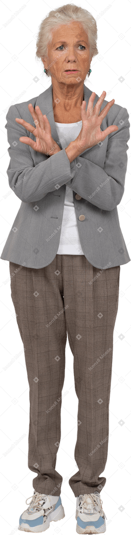 Front view of an old lady in suit showing stop gesture