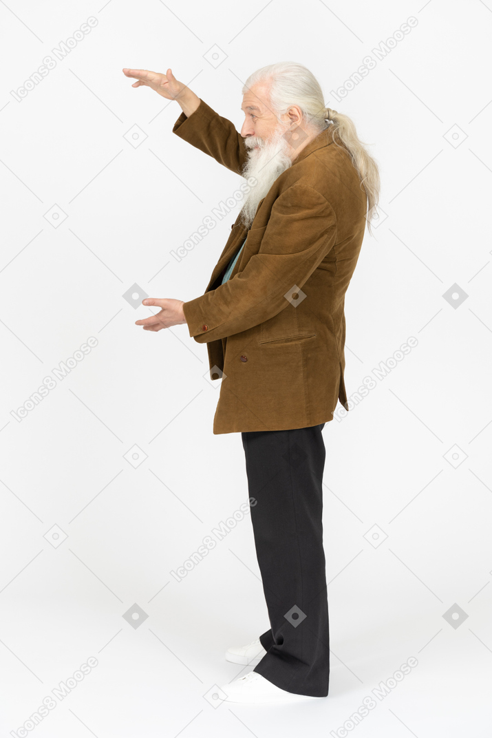 Vista laterale di un uomo anziano che mostra le dimensioni di qualcosa