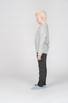 Side view of a little boy standing still