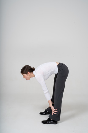 Side view of a young woman bending down