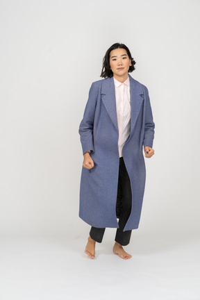Woman in coat on bent legs