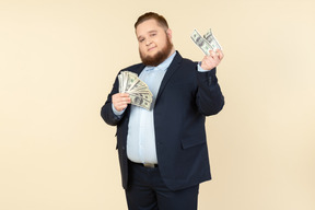 A plus-size man in a black costume with dollar bills in his hands