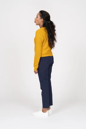 Side view of a girl in casual clothes showing tongue