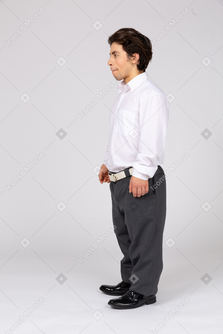 Vue latérale d'un jeune homme en pantalon et chemise