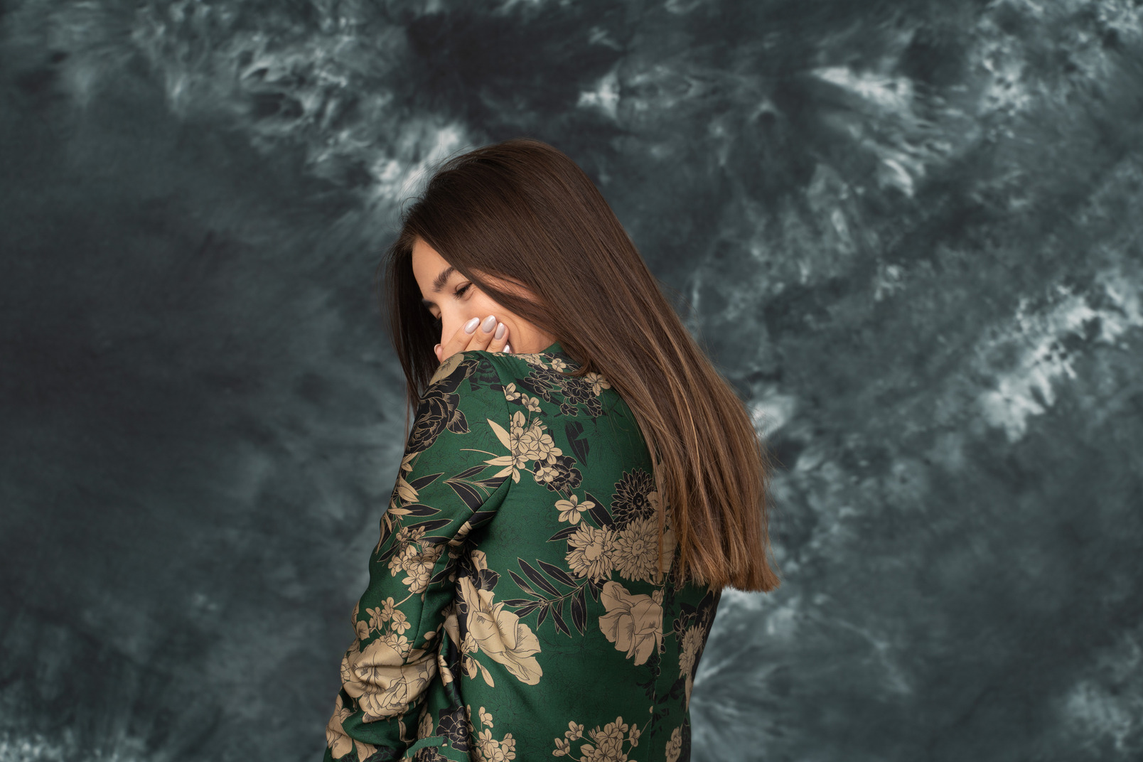 Back shot of young woman in japanese jacket laughing hides her mouth