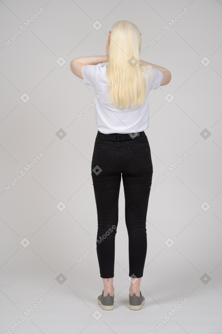 頭に手を押す長髪の女性の背面図