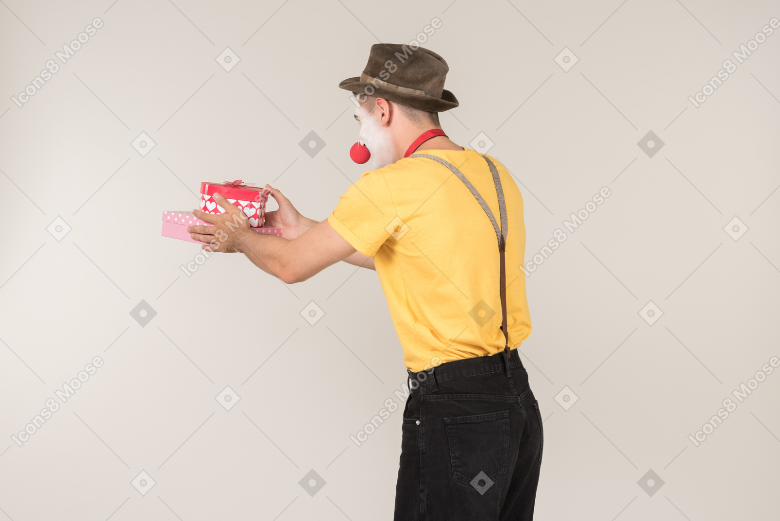 Male clown holding gift box and standing back to camera