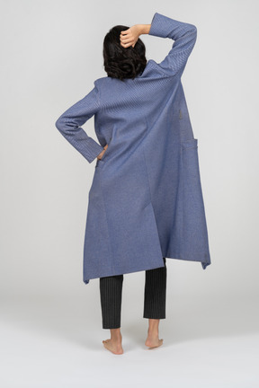 一个穿着大衣摆姿势的女人的背影