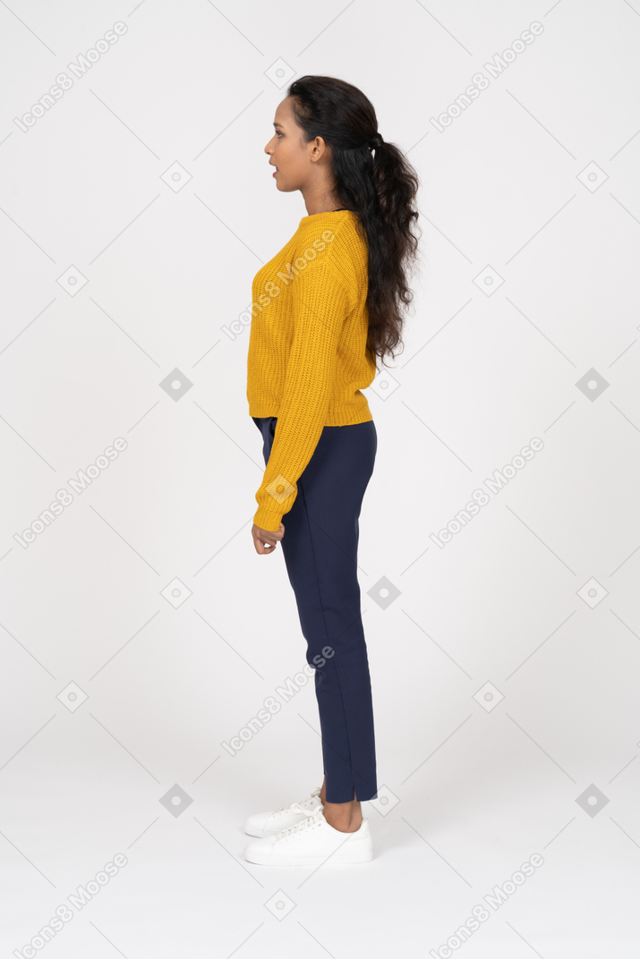 Side view of a girl in casual clothes standing with her mouth open