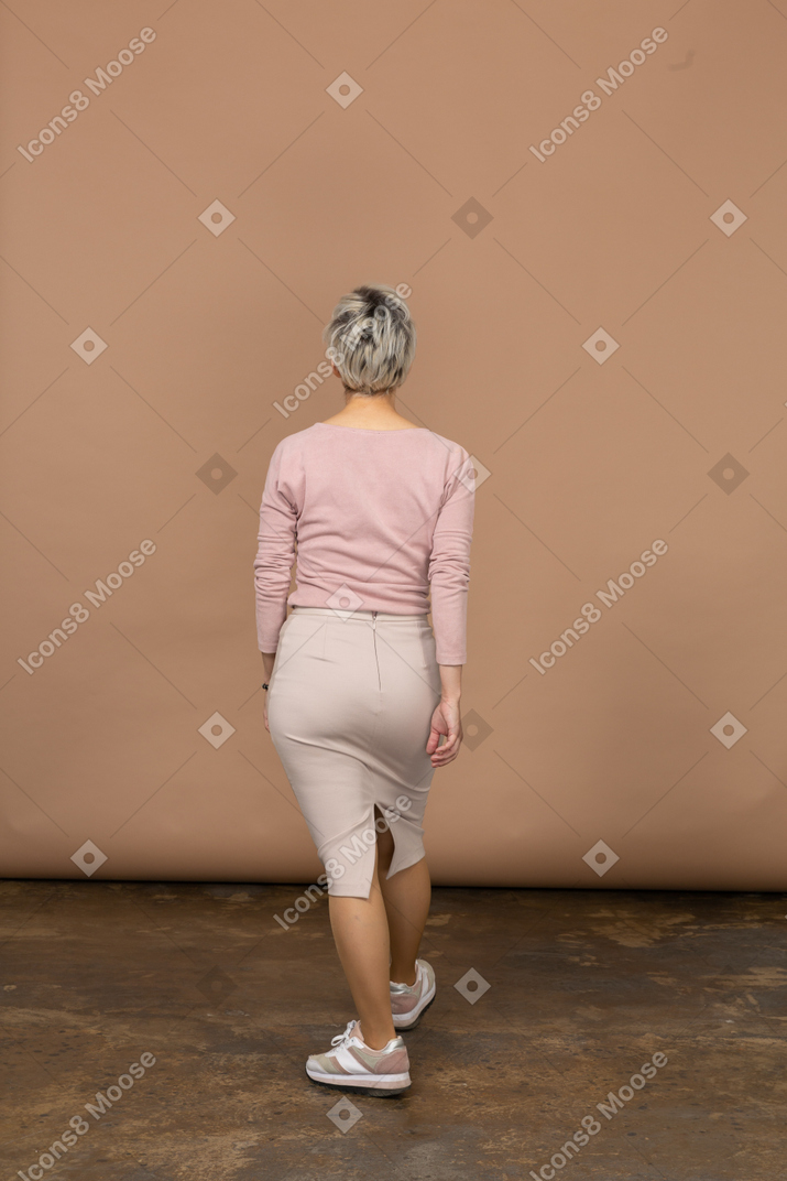 一个穿着休闲服走路的女人的后视图