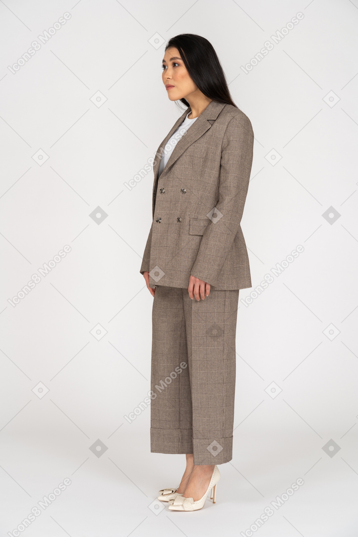 Three-quarter view of a young lady in brown business suit leaning forward