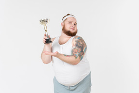 Big guy in sportswear holding trophy