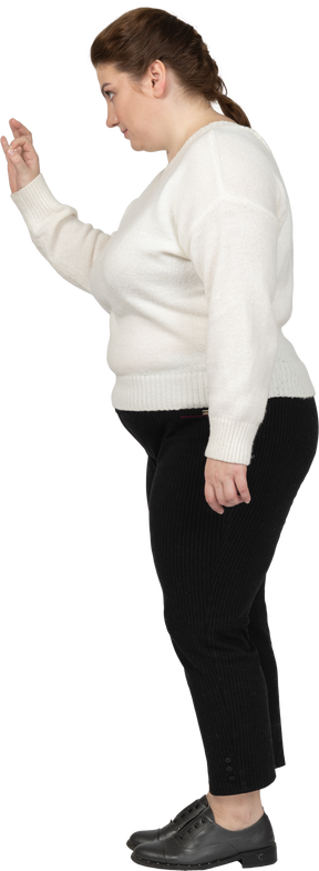 Okサインを示す白いセーターのプラスサイズの女性