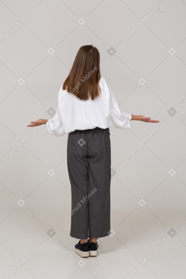 Back view of a young lady in office clothing outspreading arms
