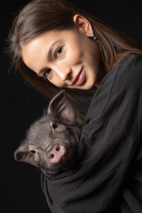 Hermosa chica con cerdo en miniatura