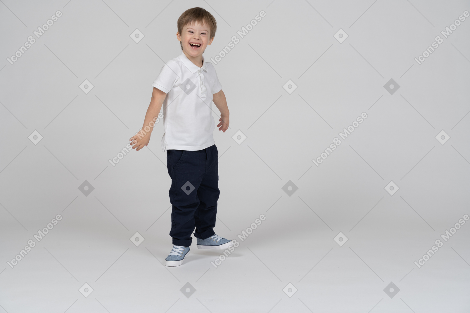 Vista de tres cuartos de un niño de pie y riendo alegremente