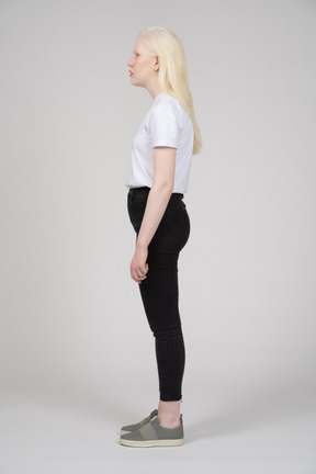 Side view of a standing young girl in casual clothes