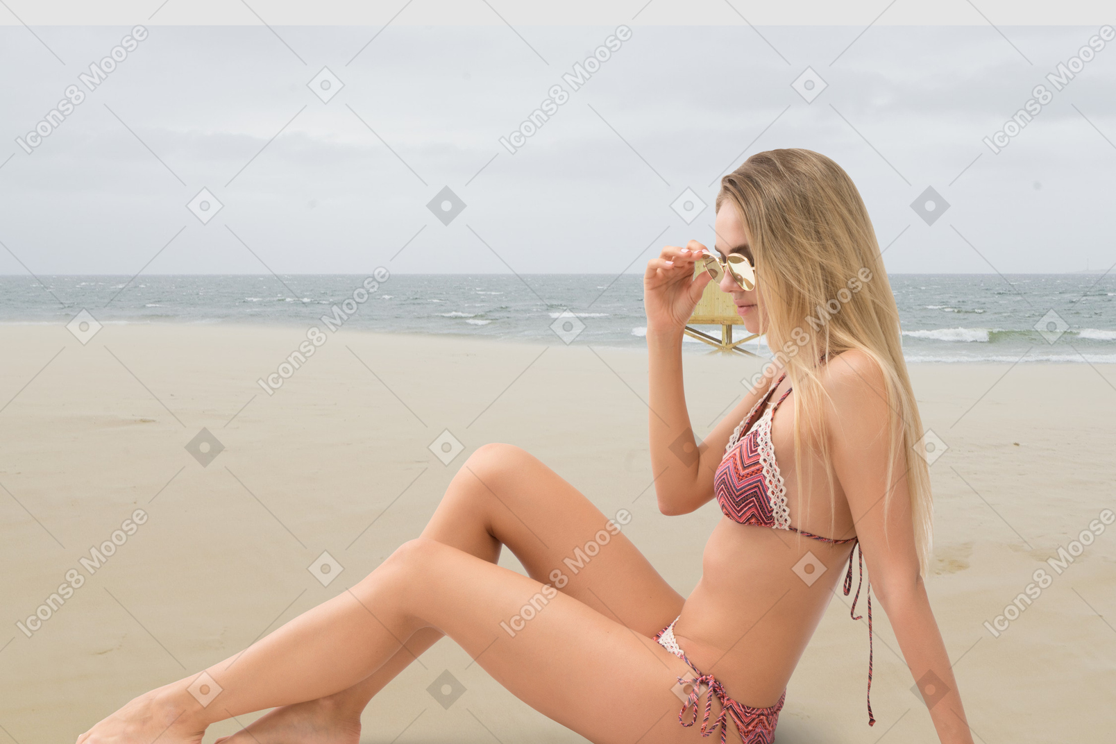Young woman holding a pineapple on the beach