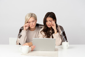 Mujeres jóvenes viendo películas y llorando