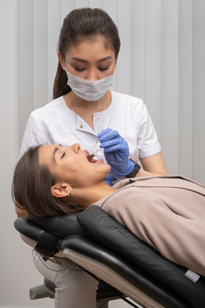 A woman getting her teeth checked by a dentist