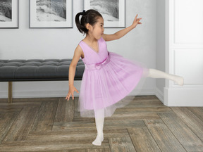 A little girl in a pink dress is dancing