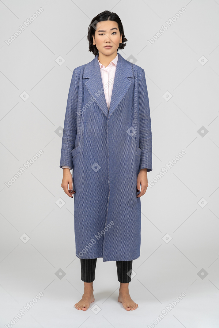 Skeptical woman in blue coat with eyebrow raised