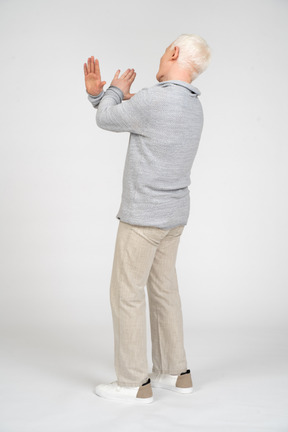 Rear view of man with hands crossed showing enough gesture