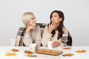 Junge frauen trinken kaffee und unterhalten sich