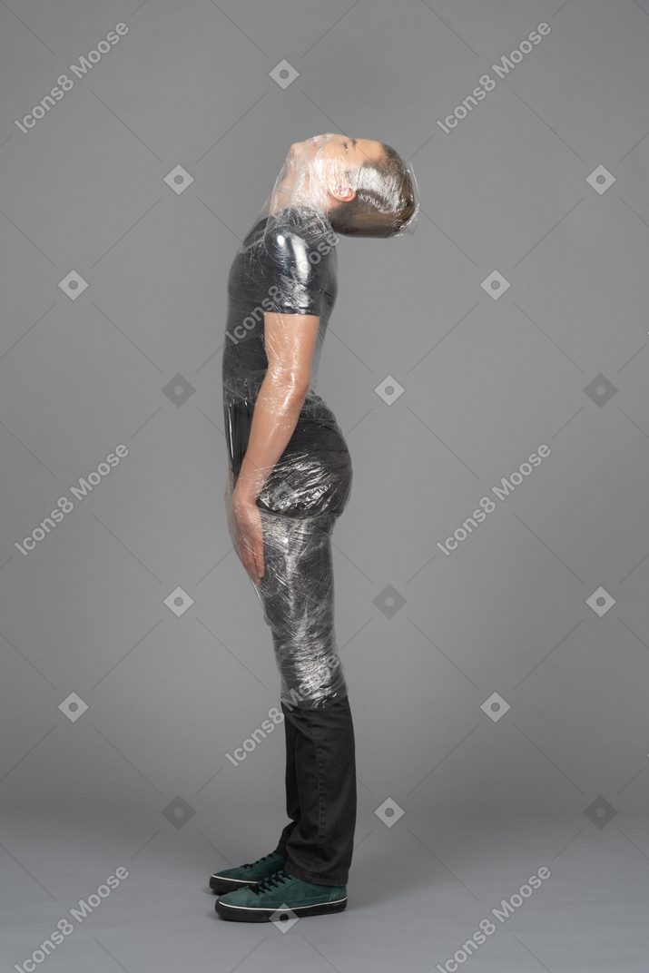 Side view of a young man wrapped in plastic